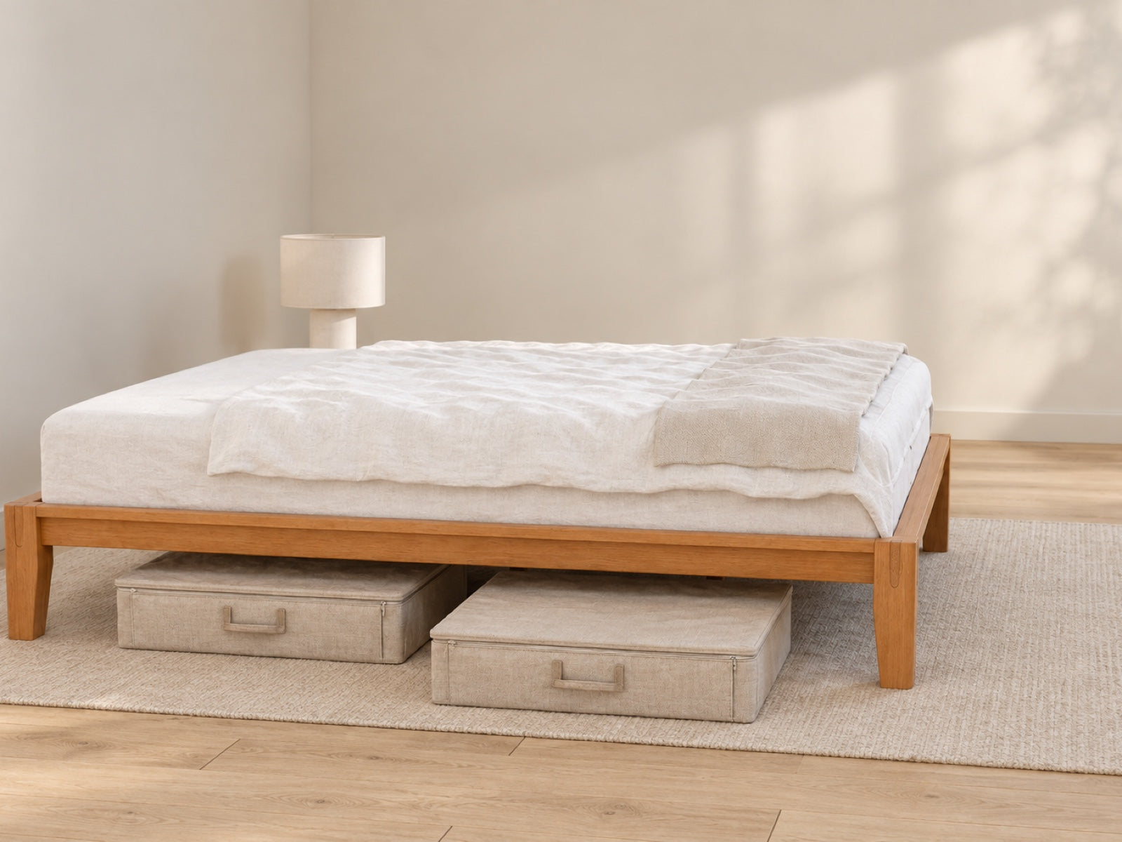 Angled long-side view of the Brintavo Queen Bed Frame with the rear leg visible and two separate low-profile fabric storage cases beneath the side rail